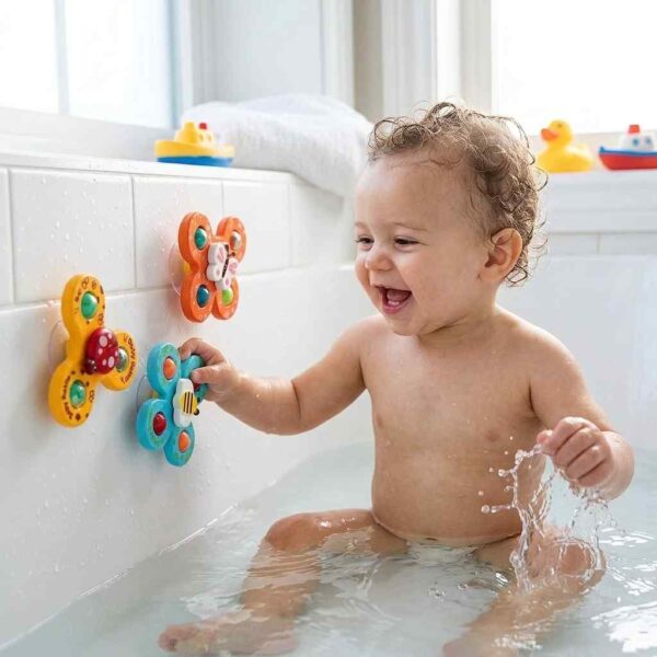 Baby playing with colorful suction toys during bath time
